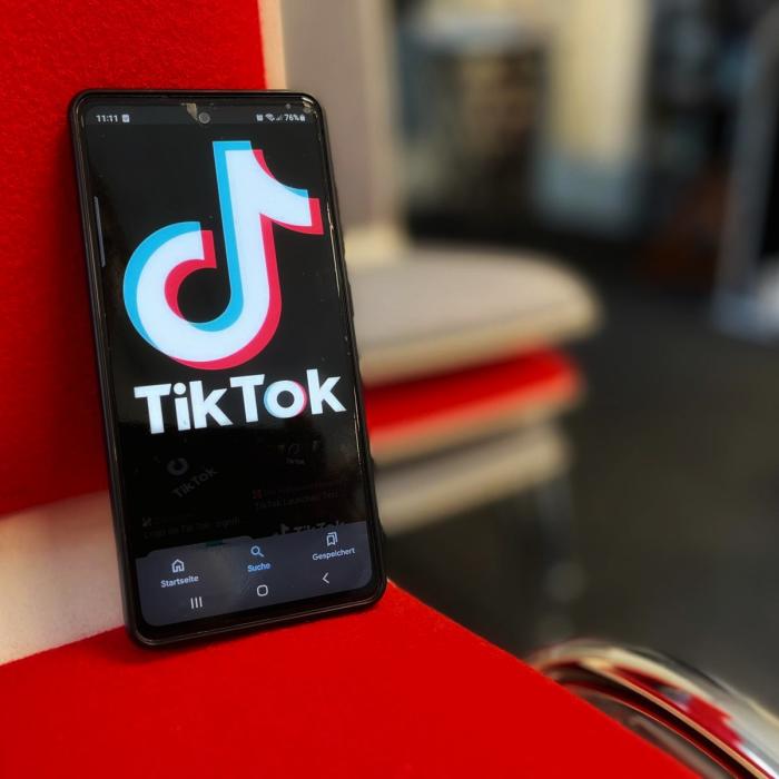 Zu sehen ist ein Smartphone und auf dessen Display das Logo von TikTok.